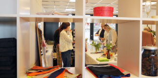 Stemning fra reception fotograferet via åben reol med tekstilprodukter